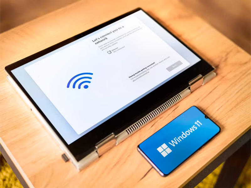 offline installation of windows 11 on a laptop and a phone with the windows 11 logo